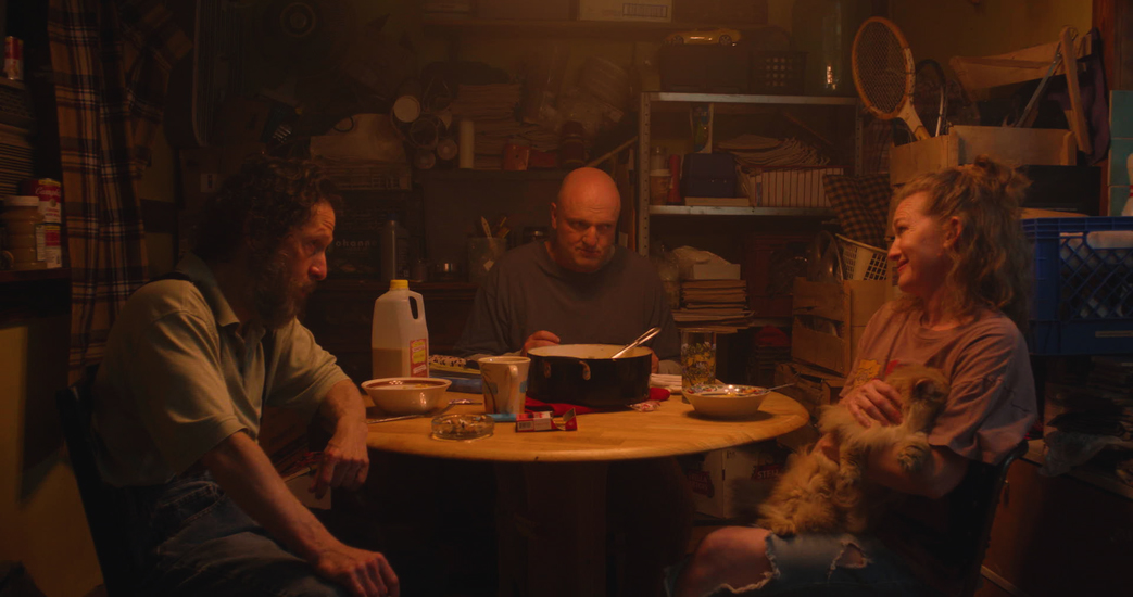 Tim Blake Nelson, Mirelle Enos, and Matt Maher sit at a kitchen table